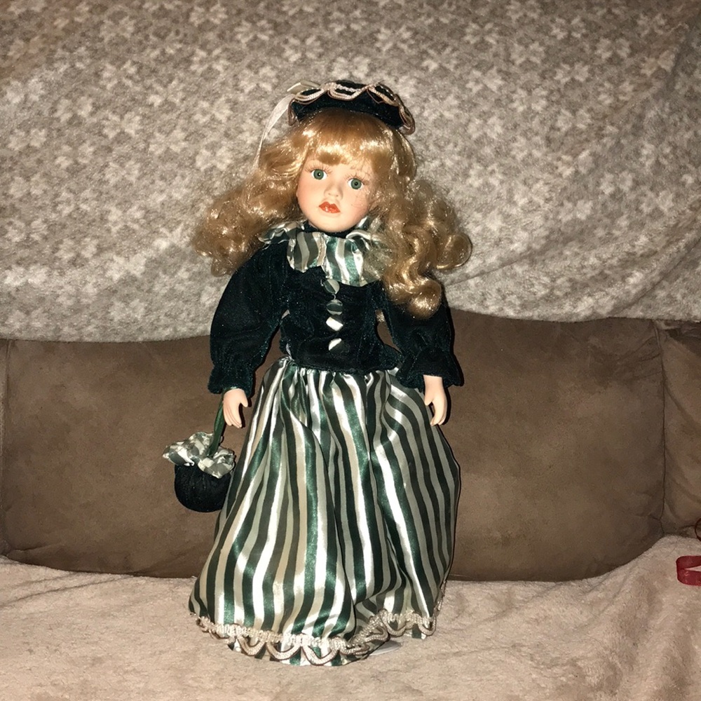 Porcelain collectors doll on stand green dress